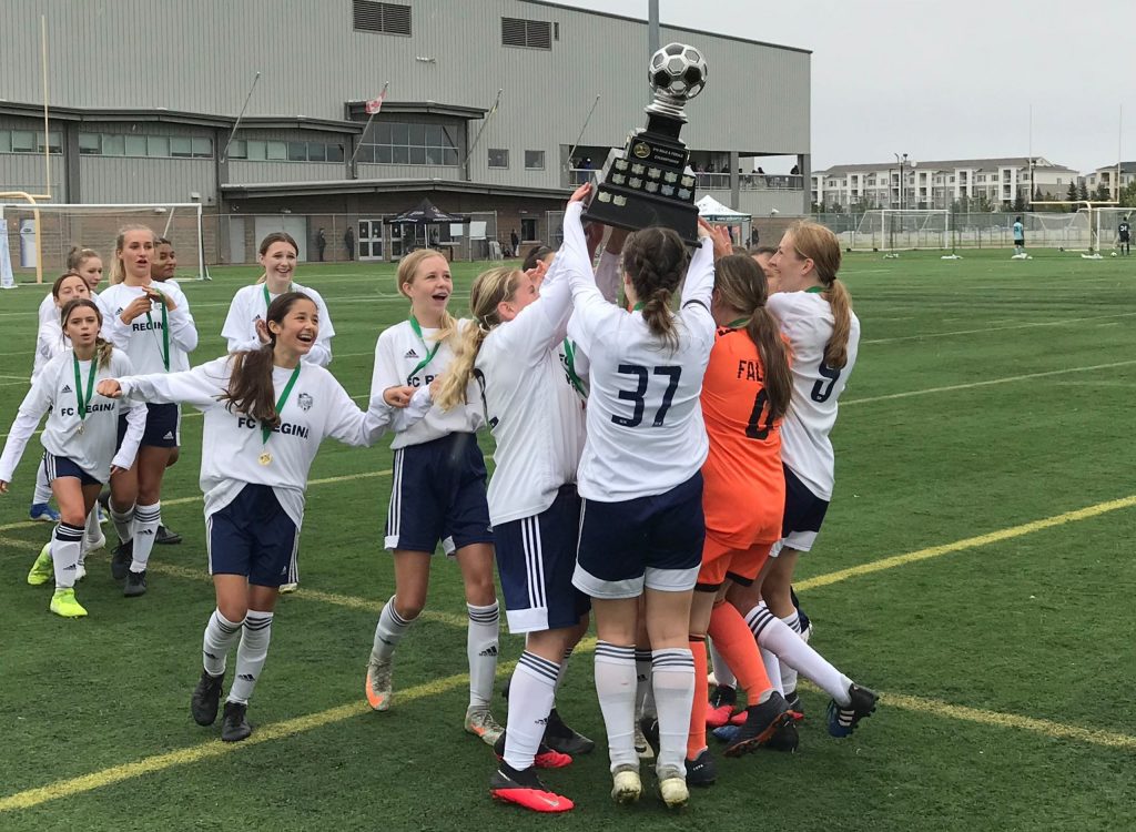 Girls soccer players celebrate win.
