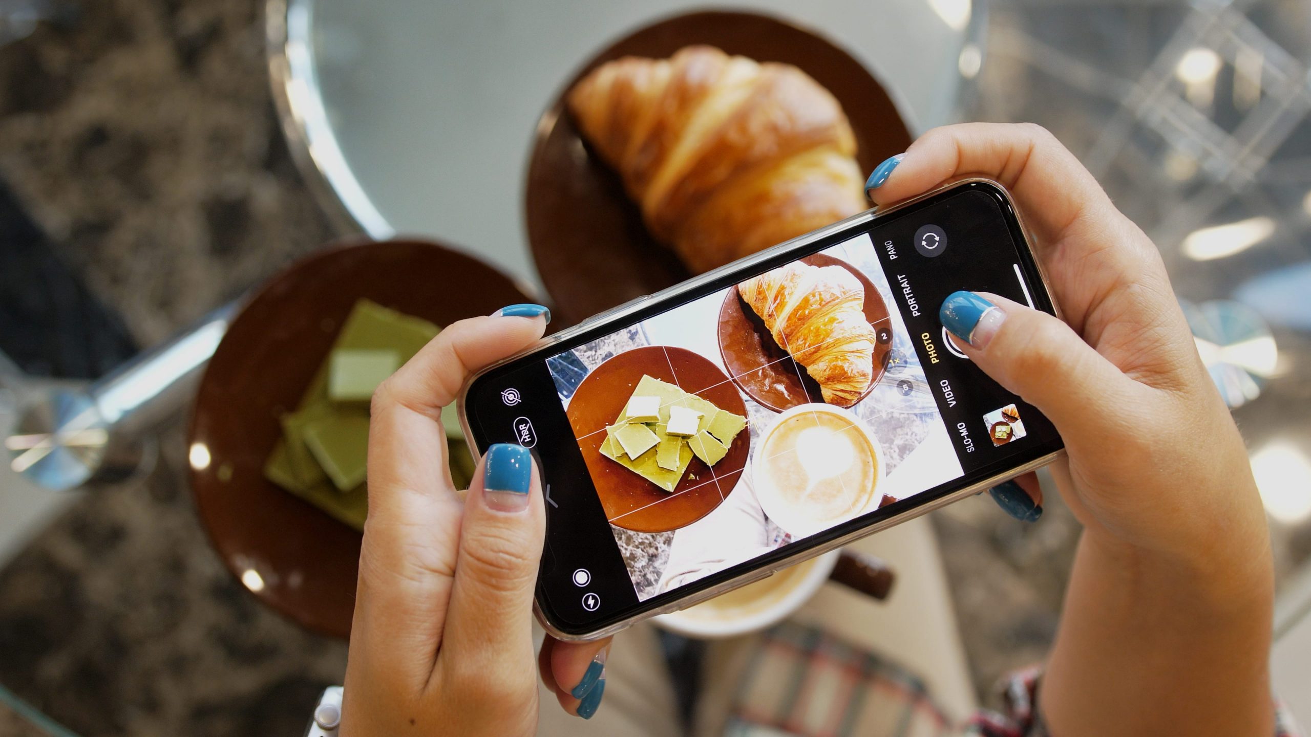 person taking picture of breakfast food via cellphone