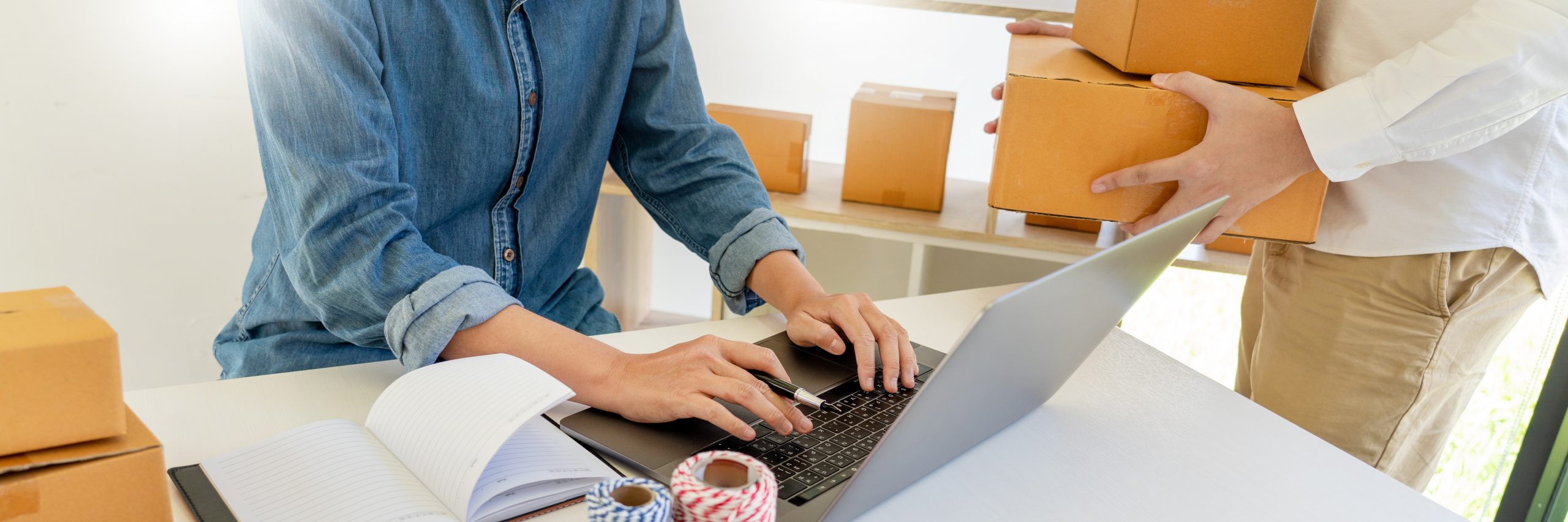 Startup small business entrepreneur SME, young asian man working with laptop computer and delivery packaging box, online market packing, SME e-commerce seller concept. Directwest Industry statistics